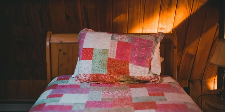 Roze patchwork sprei en kussen op bed