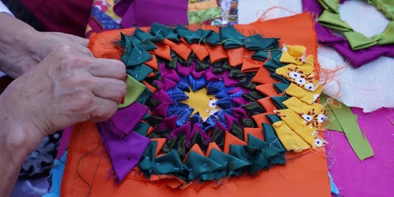 Handwerk aan kleurrijk patchworkblok