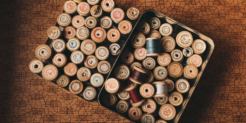 Vintage houten garenklosjes in blikken doos