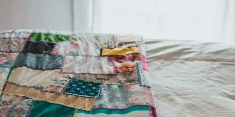 Patchwork quilt op een bed in warme kleuren