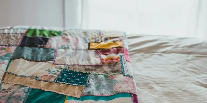 Patchwork quilt op een bed in warme kleuren